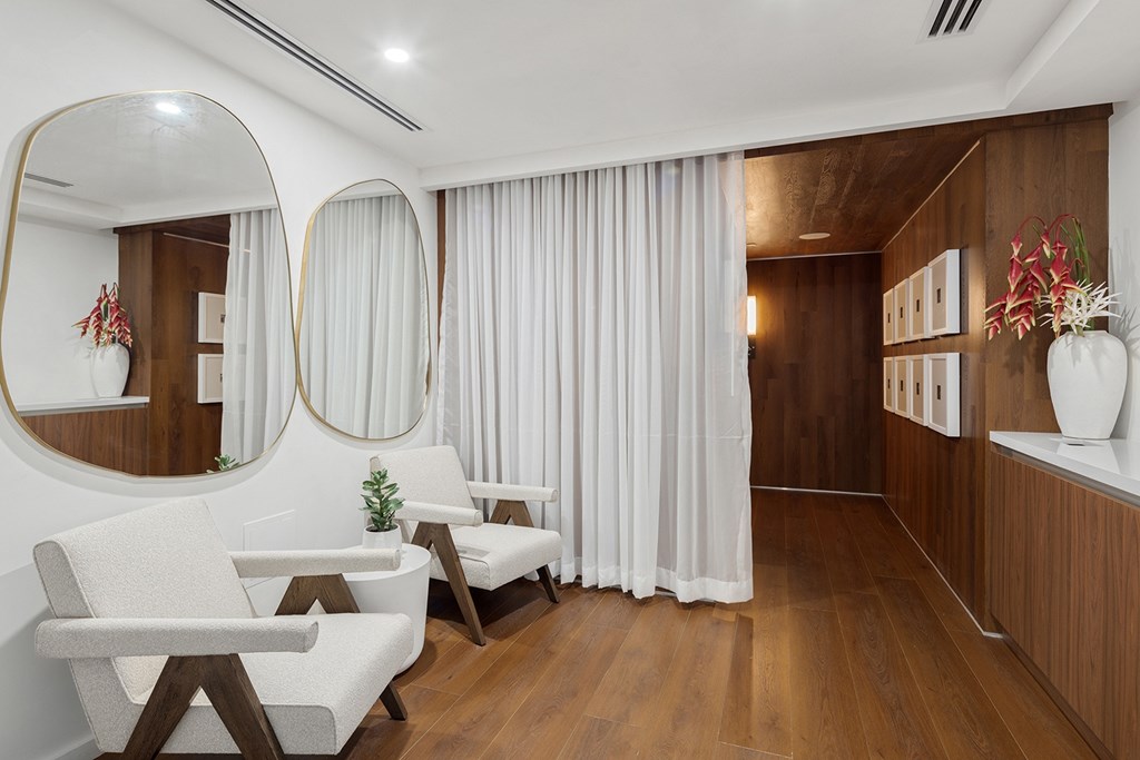A modern living room with white furniture and wooden accents.