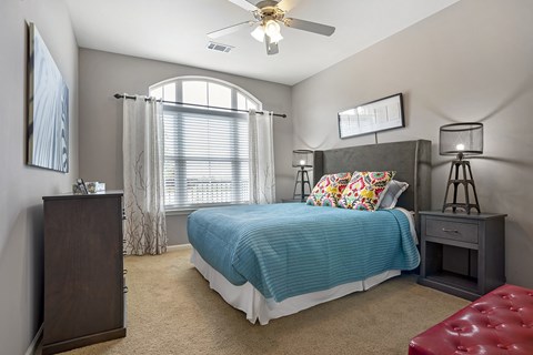 a bedroom with a bed and a ceiling fan