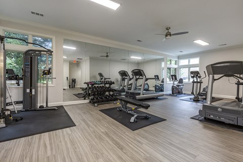 Spacious fitness center with cardio machines and weights at The Apartments at The Sycamores, Virginia