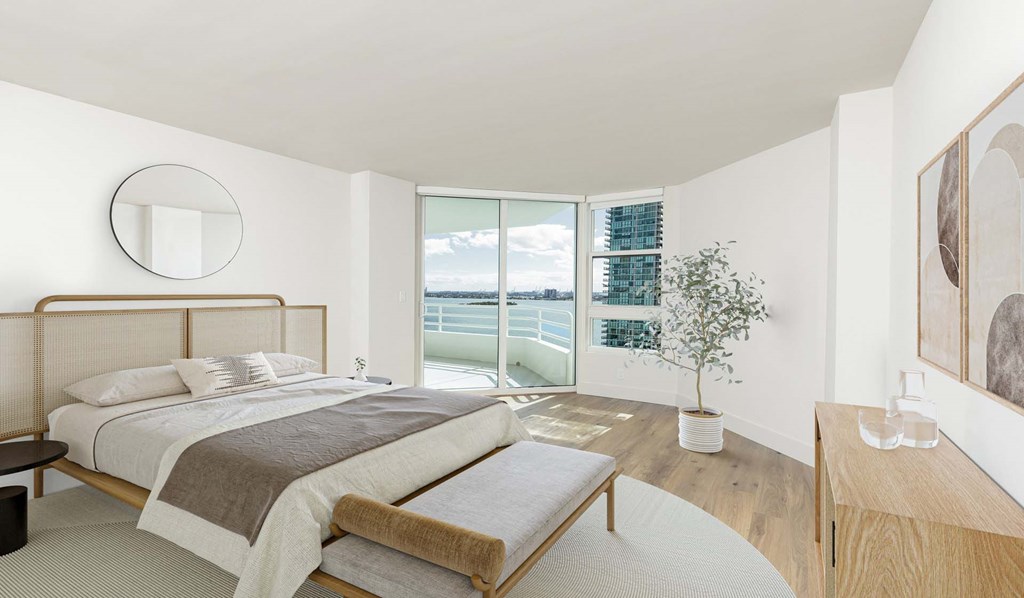 A bedroom with a large bed and a view of the city.