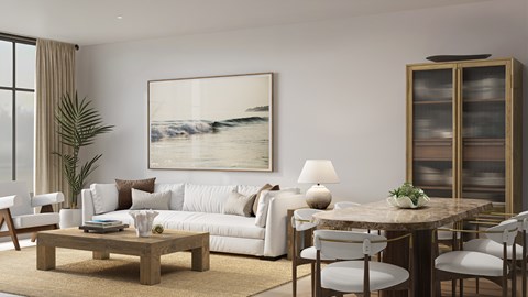 A living room with a white sofa, a wooden coffee table, and a large painting on the wall.