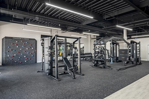a gym with weights machines and a rock wall at Villaggio Apartments, Bossier City, LA