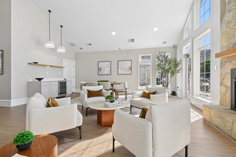 A living room with white furniture and a fireplace.