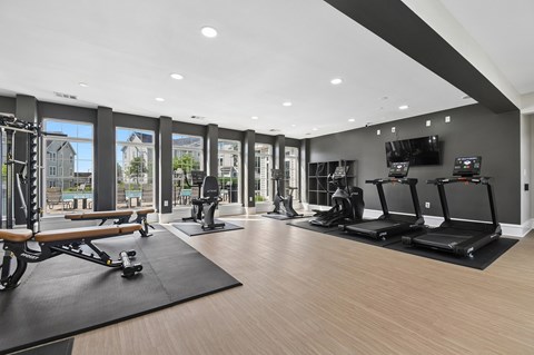 A gym with treadmills, elliptical machines, and a rowing machine.