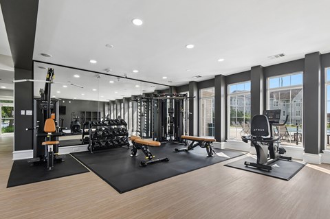 A gym with a variety of equipment including weights and cardio machines.