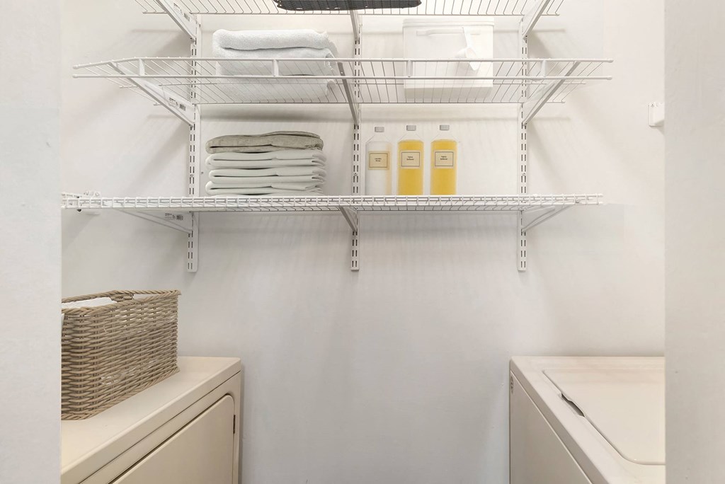 a laundry room with a sink and a shelf with towels