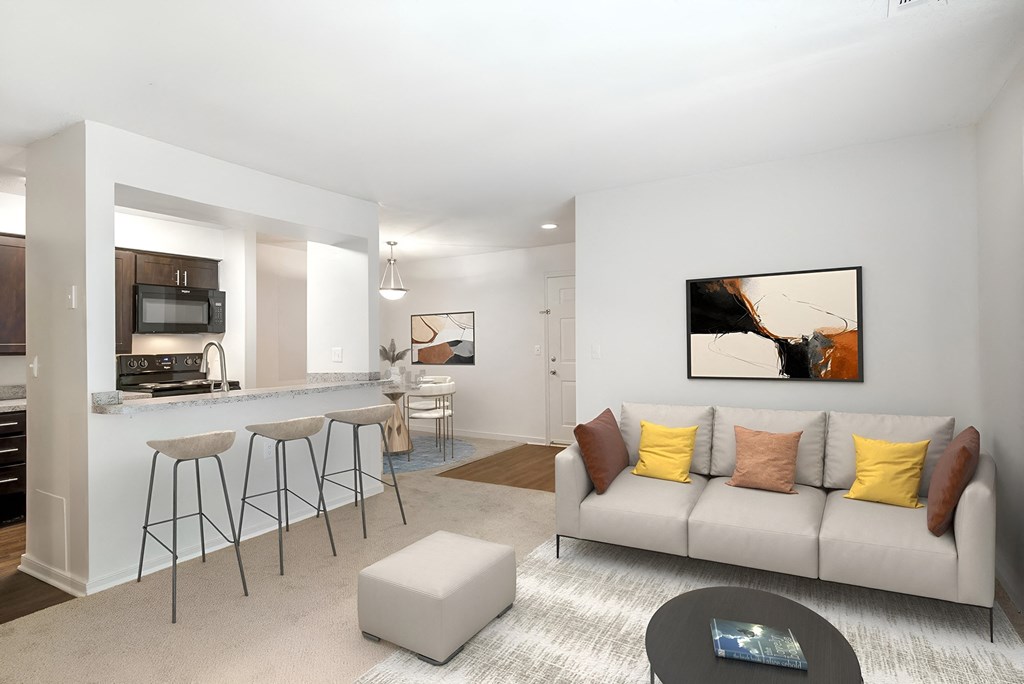 a living room with a couch and a kitchen with a bar