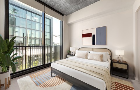 A bedroom with a large bed and a balcony with a view of the city.