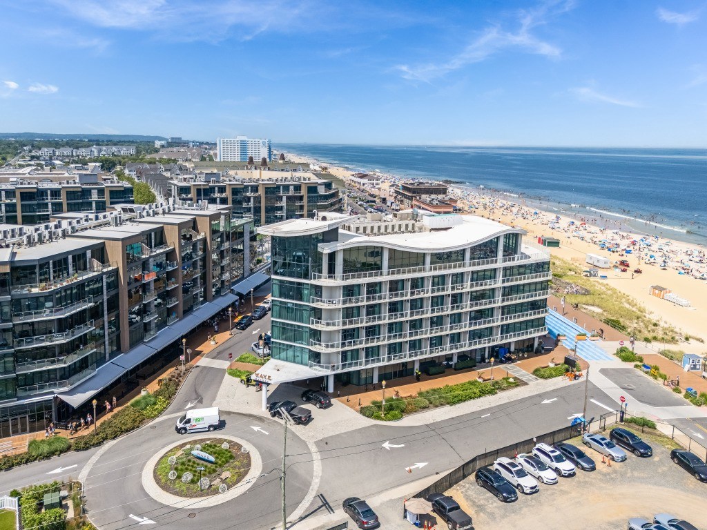 A view of a roundabout with a building in the background and a beach in the distance.