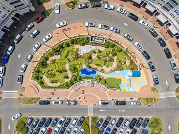 An aerial view of a roundabout with a park in the middle.