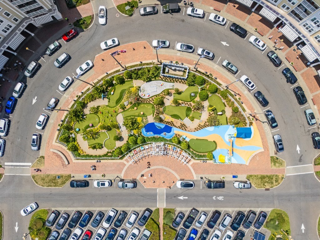 An aerial view of a roundabout with a park in the middle.