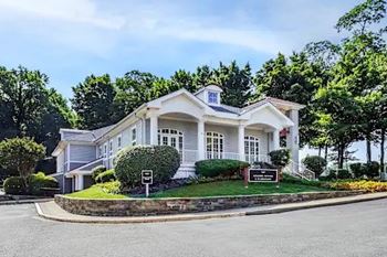 A white house with a black sign in front.