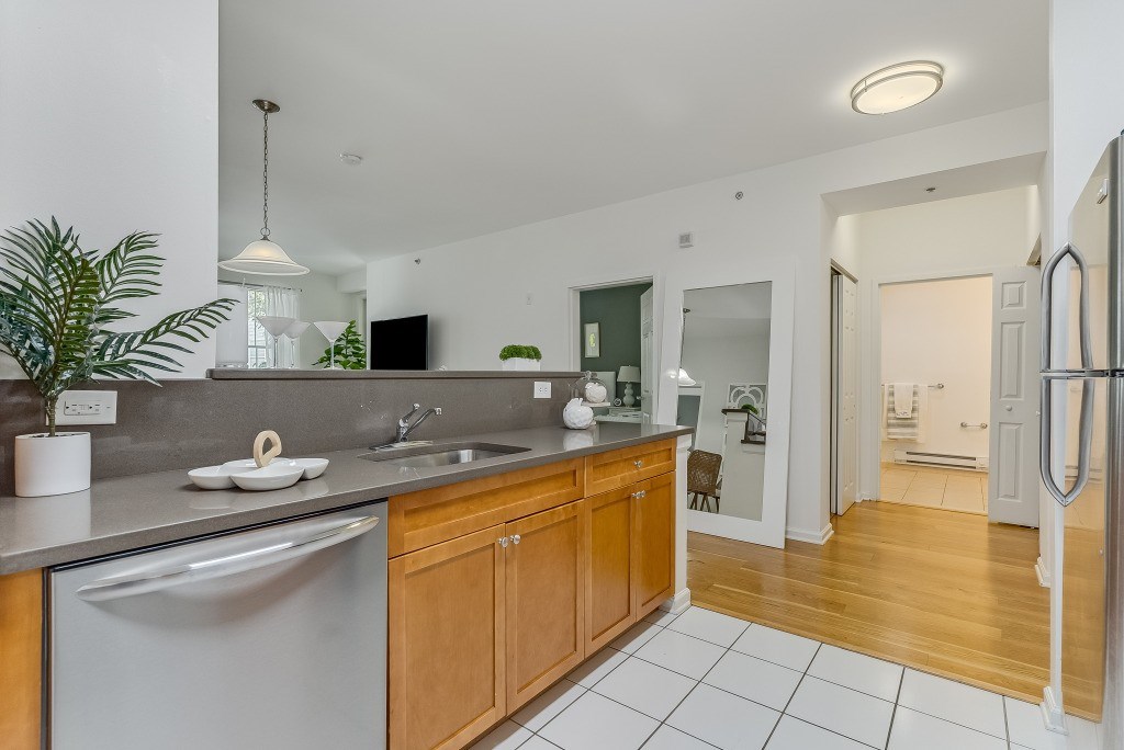 A modern kitchen with wooden cabinets and a white fridge.