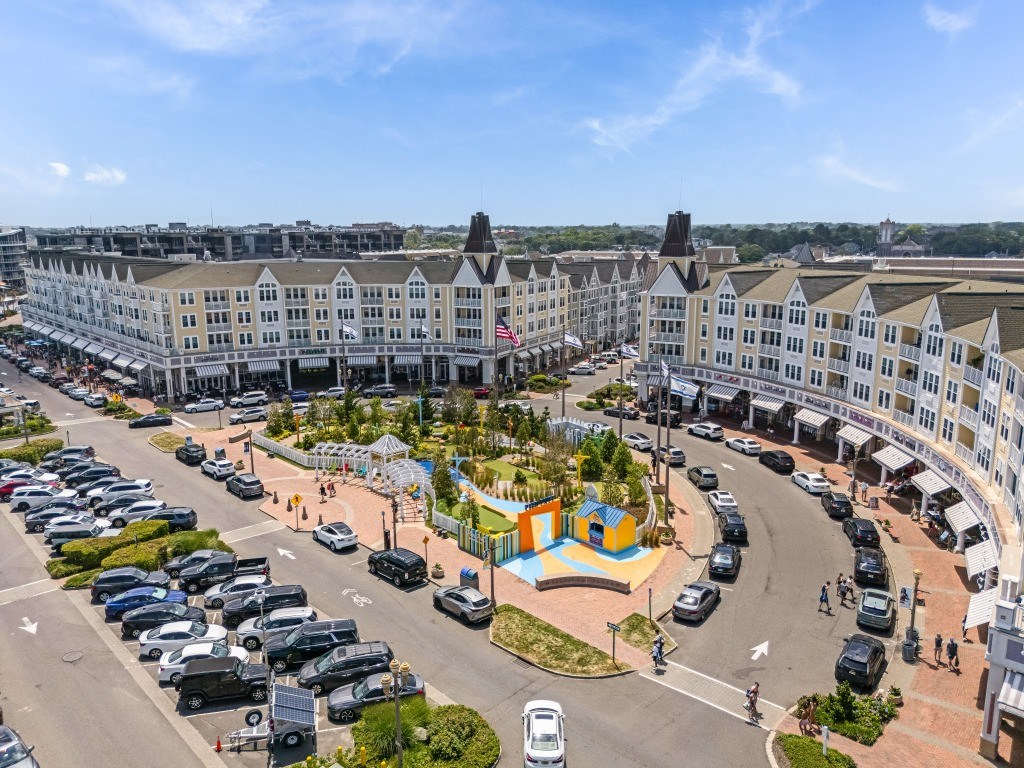 A view of a parking lot with cars and a colorful playground in the foreground.