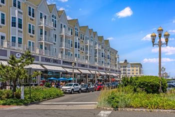 A street view of a hotel with cars parked in front and a clear blue sky.