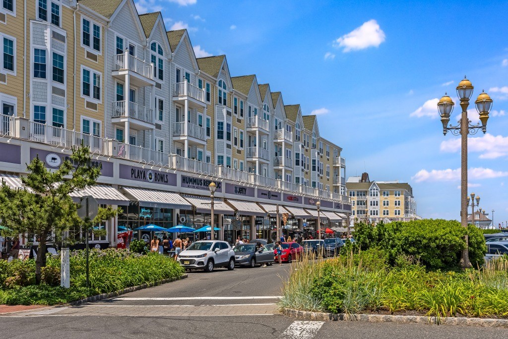 A street view of a hotel with cars parked in front and a clear blue sky.