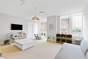 A living room with a grey couch and a white coffee table.