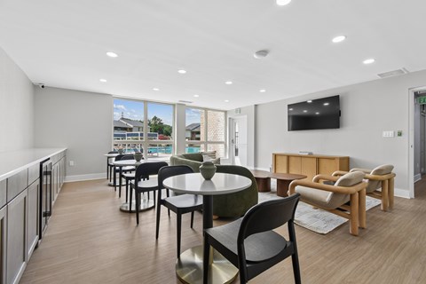 A modern dining area with a table set for six and a television mounted on the wall.
