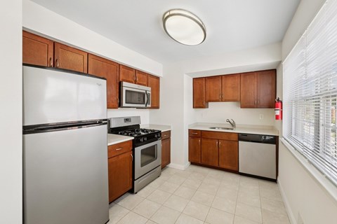 A kitchen with white appliances and brown cabinets.