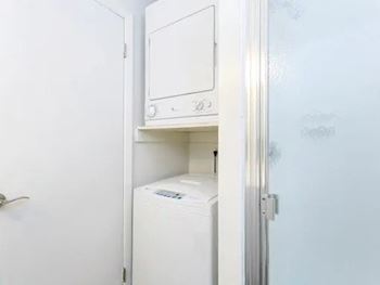A white dryer is in a small closet.