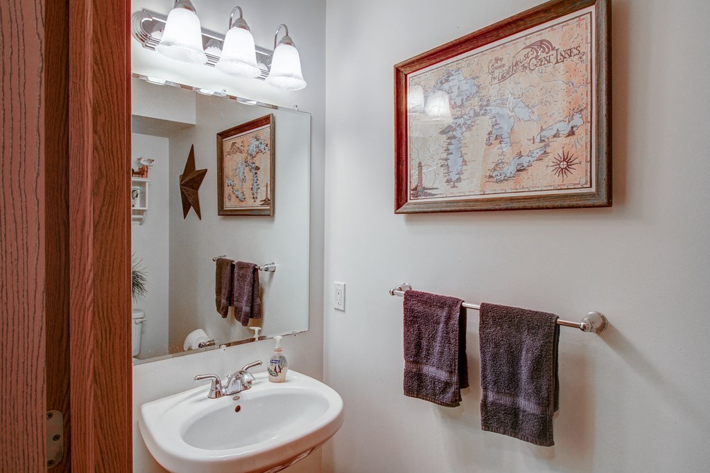 a bathroom with a sink and a mirror and towel racks