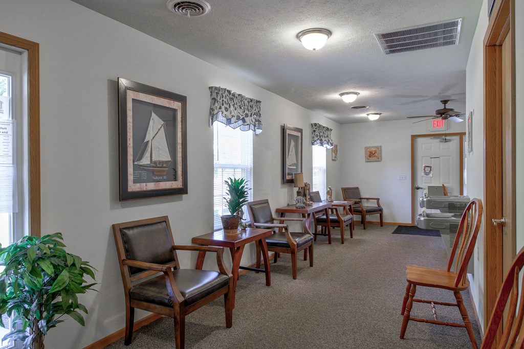 a dining room with tables and chairs and a living room with a staircase