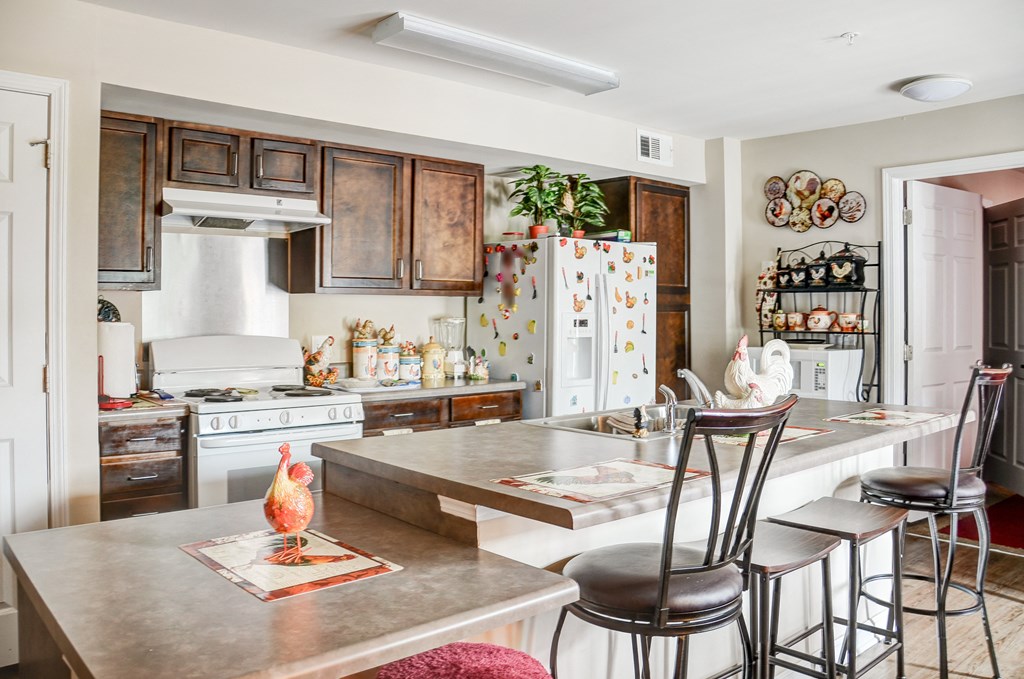 a kitchen with a center island and stools in front of a kitchen counter top