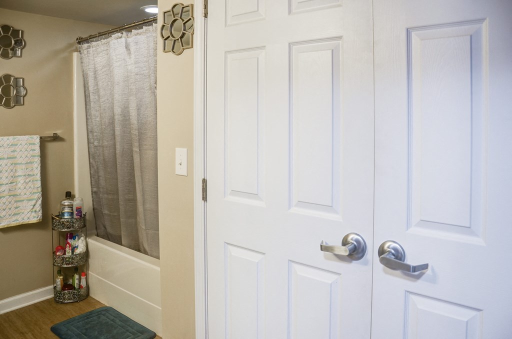 a bathroom with a white door and a shower and a sink