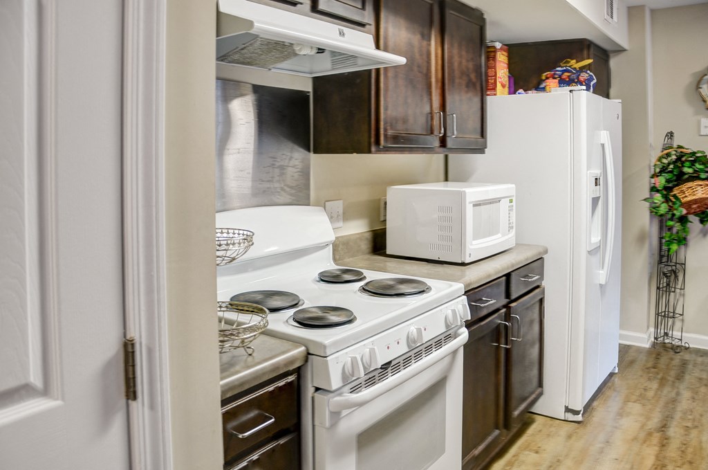 a small kitchen with a stove microwave and refrigerator