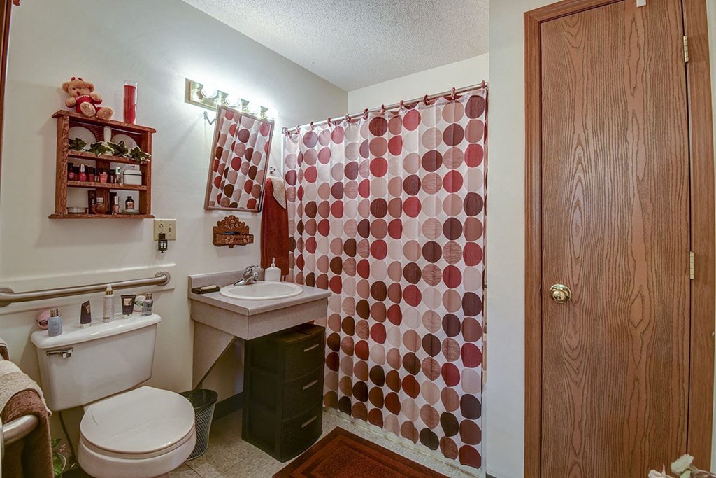 a bathroom with a shower and a toilet and a sink