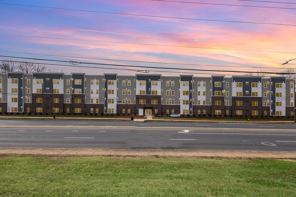 A long row of identical townhouses are lined up on a street.