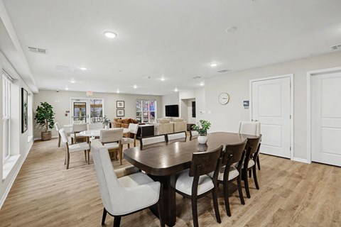 A dining room with a table surrounded by chairs.