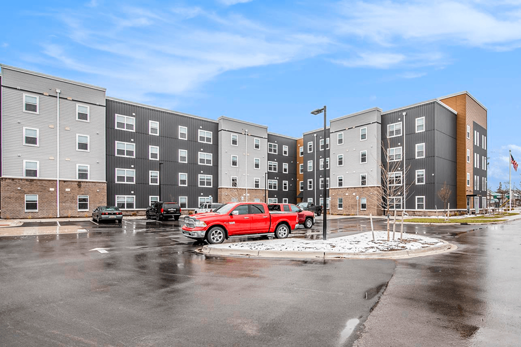 a red truck parked in front of an apartment building