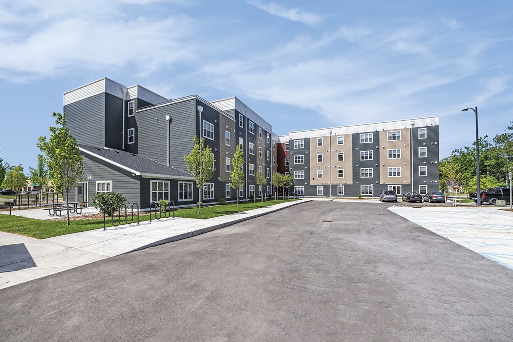 an empty parking lot in front of an apartment building