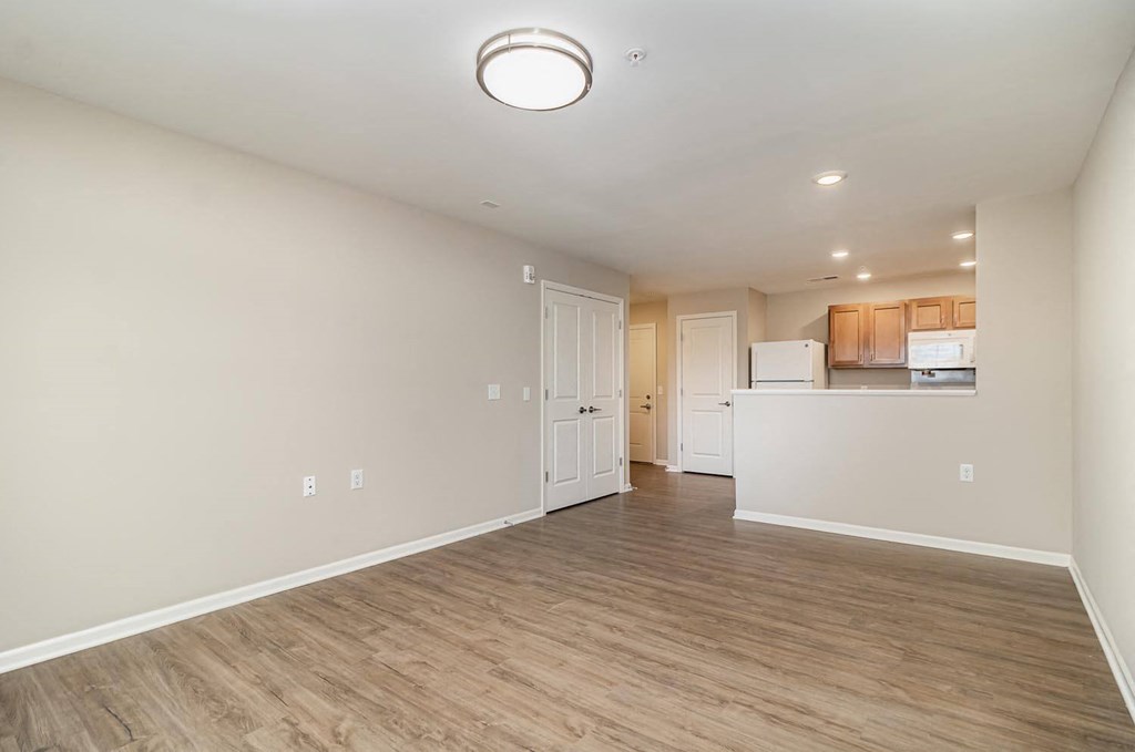 a living room and kitchen with a wood floor