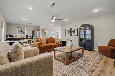 A living room with a brown couch, a coffee table, and a rug.