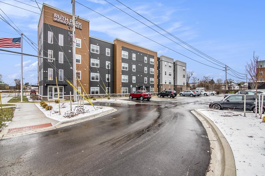 a new apartment building with cars parked in front of it
