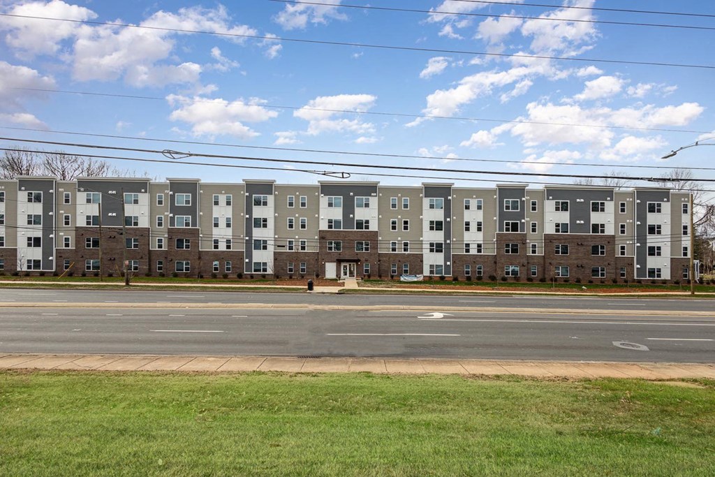 Apartment building with a green lawn in front.