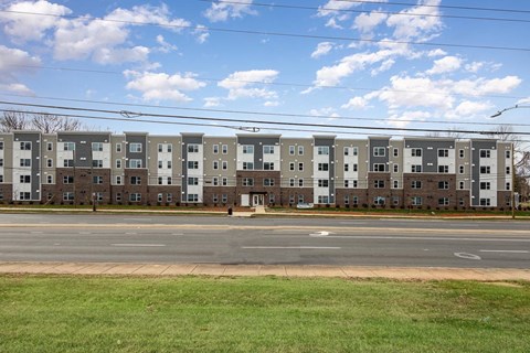 Apartment building with a green lawn in front.