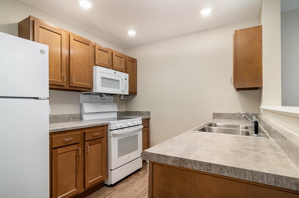 a kitchen with white appliances and wooden cabinets
