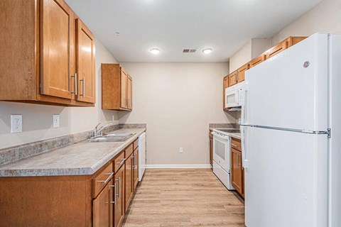 A kitchen with wooden cabinets and a white refrigerator.
