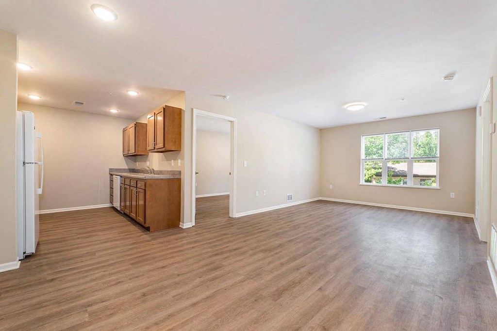 a kitchen and living room with a refrigerator and a window