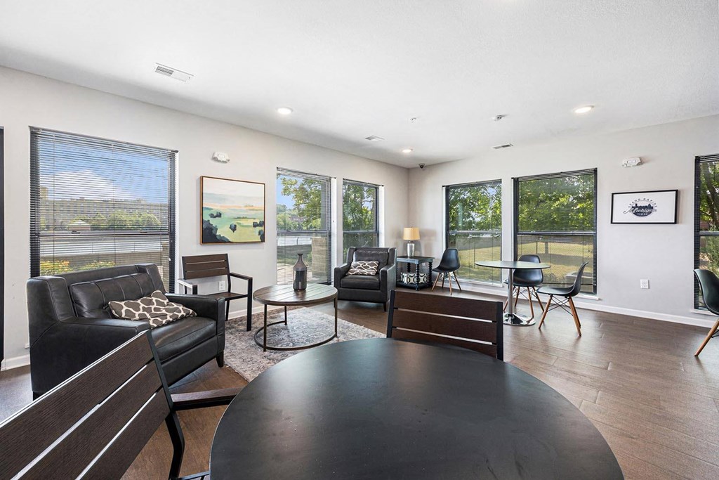 a living room with couches and a table    and large windows