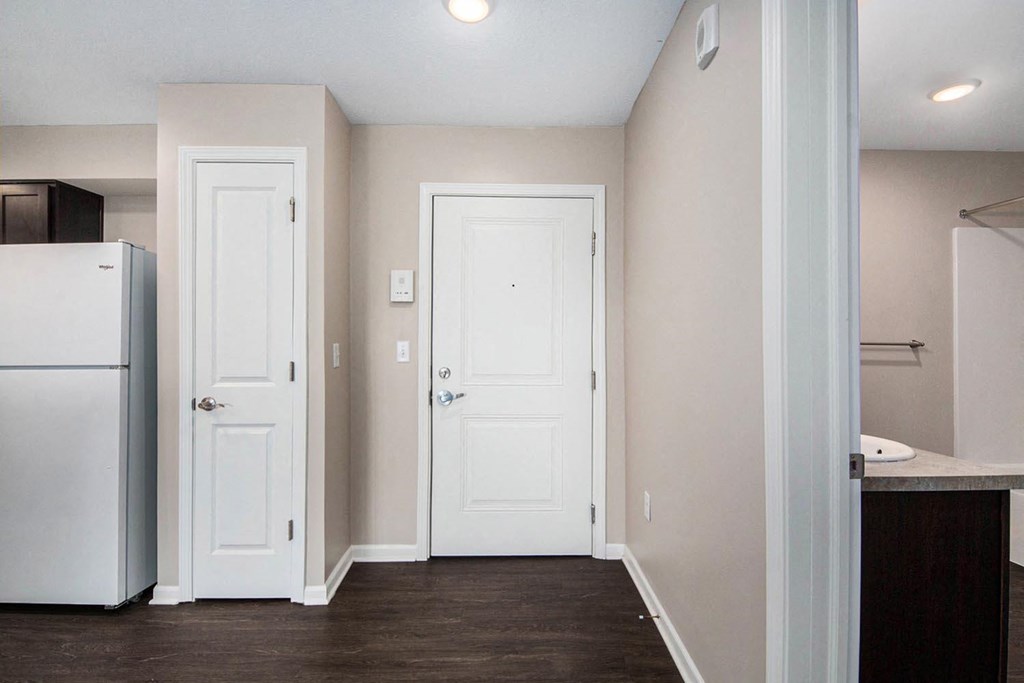 a renovated kitchen with white doors and a refrigerator