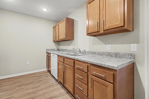 A kitchen with wooden cabinets and a marble countertop.