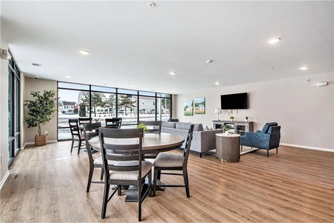 A spacious living room with a large window overlooking a street.