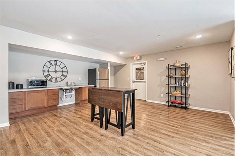 A room with a wooden floor and a large clock on the wall.