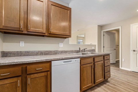 a kitchen with wooden cabinets and a white dishwasher