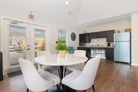 a dining room with a table and chairs next to a kitchen