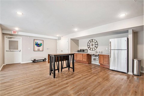 A kitchen with a white fridge and a wooden table.